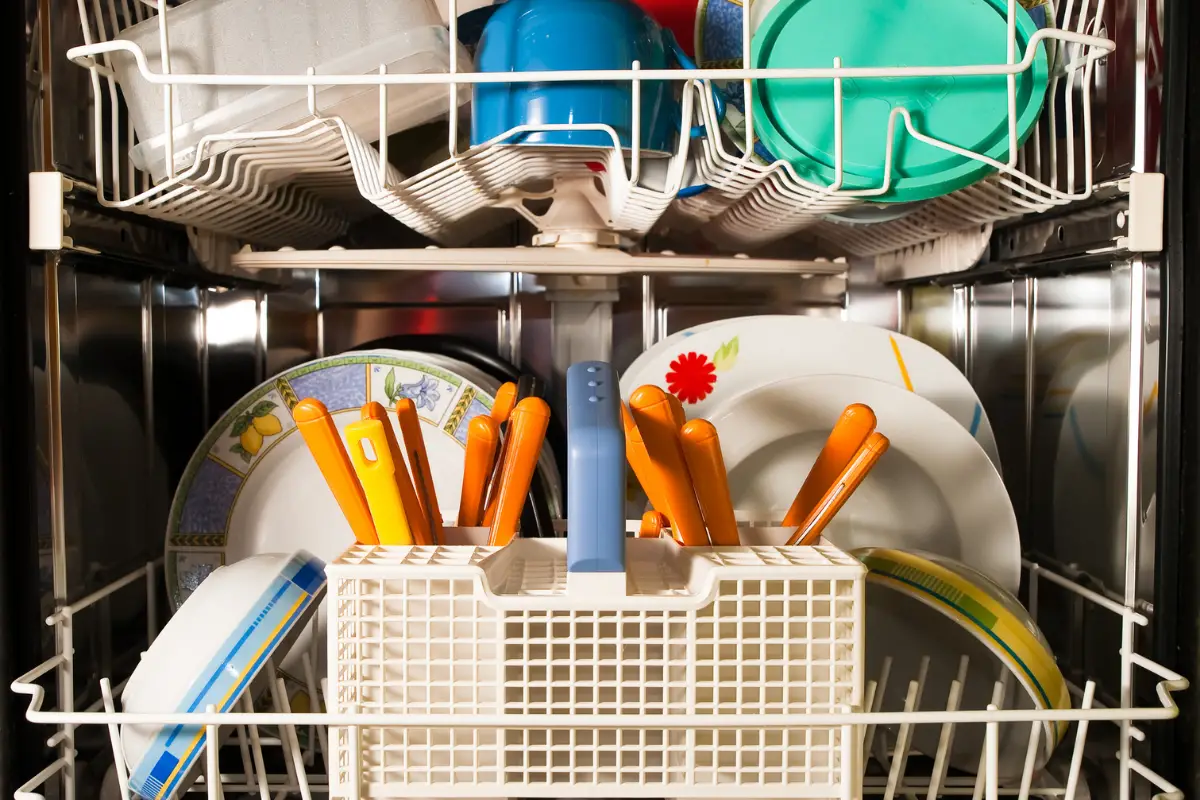 utensils, plates, and cups inside an open dishwasher