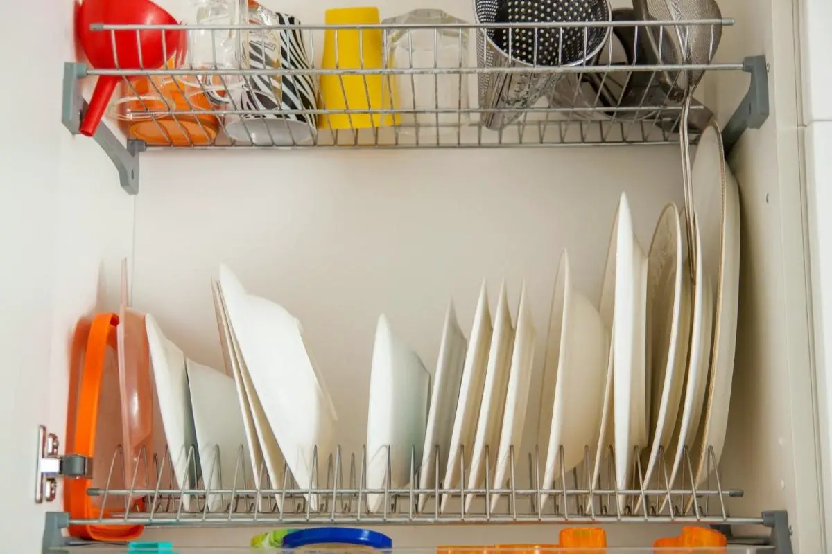 dishes stacked on a rack inside a cabinet